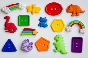 Colorful rainbow dinosaur frog bug buttons on a white background