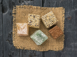 Top view of the pieces of Turkish delight on a piece of burlap on a wooden table.