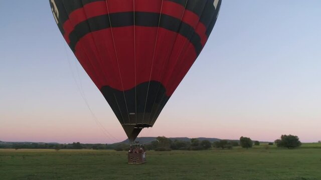 Aerial drone shot of hot air balloon in the sky near lake Balaton with beautiful sunset in the background