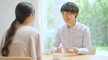 室内で会話をする若いカップル