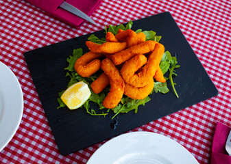 Fried sepia in a batter of tempera flour with lemon and arugula