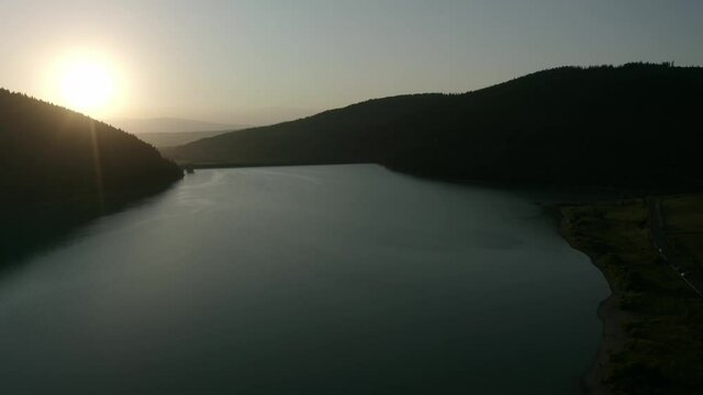 Bright Sunset At The Frumoasa Dam Surrounded With Green Landscape In Frumoasa, Romania. aerial