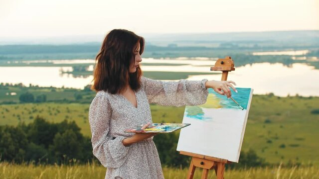 Young woman drawing a painting inspired by nature