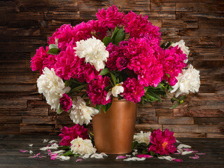 Still life with a bouquet of peonies on wood background