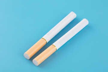 Two cigarettes on blue background