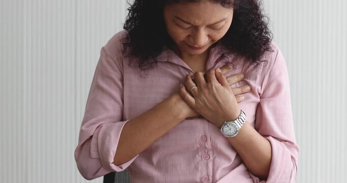 A senior Asian woman feels suffer and pain from headaches using her hand holding head. Concept of older person health care.