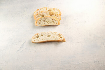sliced focaccia with herbs on white textured background. top view. flat lay.
