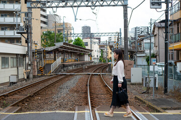 Naklejka premium 日本の電車の踏切を歩く女性