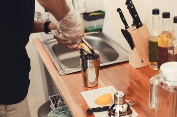 man's hand squeezing fresh oranges in the kitchen