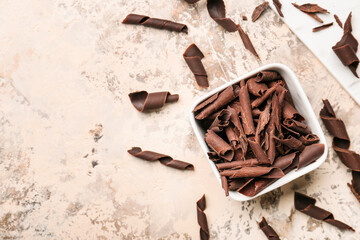 Bowl with delicious chocolate curls on grunge background