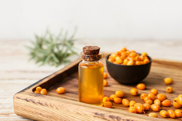 Bottle of sea buckthorn essential oil on table