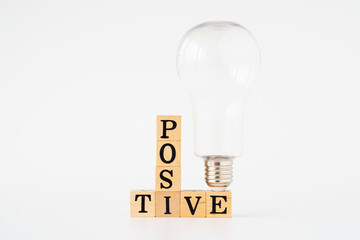 positive thinking symbol. Wooden cubes with words 'positive'. light bulb. white background.