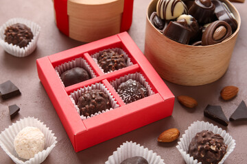 Boxes with sweet chocolate candies on color background