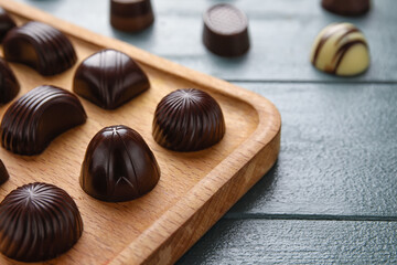 Board with sweet chocolate candies on table