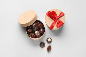 Box with sweet chocolate candies on light background