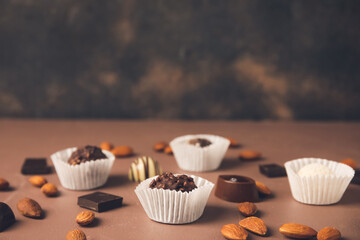 Sweet chocolate candies with nuts on table