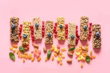 Gordijnen Healthy cereal bars, berries and nuts on color background © Pixel-Shot