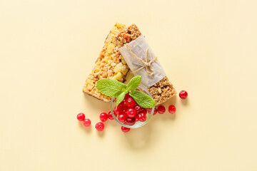 Healthy cereal bars and cranberries on color background