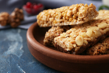 Plate with healthy cereal bars on color background
