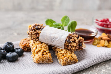 Healthy cereal bars, berries and nuts on grey background