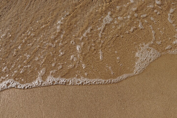 Tidal waves with ripples and foam on sea coast