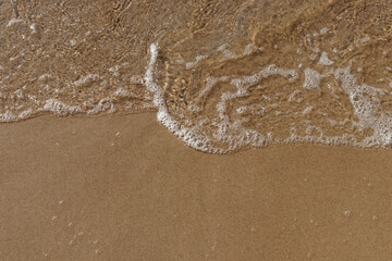 Tidal waves with ripples and foam on sea coast