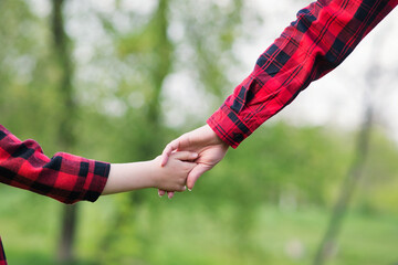 Parent holds the hand of small child. International family day concept. Mom and Son. Family time together