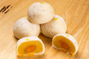 High angle view of whole and two halves chinese pastry or moon cake filled with sweet mung bean paste and salted egg yolk.