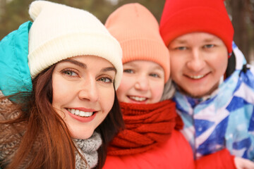 Happy family taking selfie in park on winter day