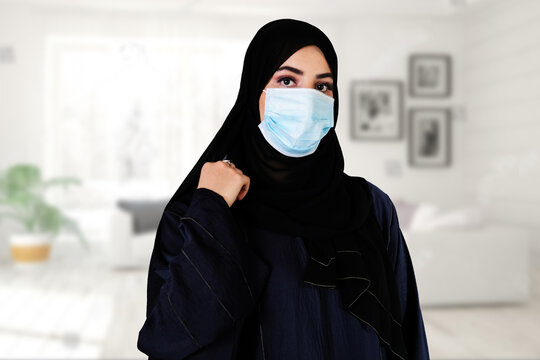 Middle East Arab woman wearing face mask, abaya and hijab while at home