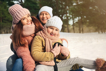 Fototapeta na wymiar Happy family sledging in park on winter day