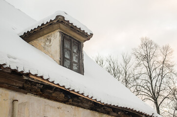 Roof window and tiles in snowy winter day, Kuldiga, Latvia.