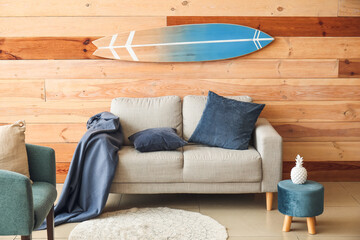 Interior of modern stylish room with sofa and surfboard