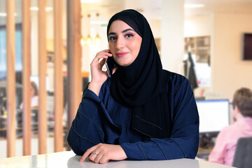 Emirati Arab business woman wearing Hijab and Abaya using mobile phone. Mulicultural concept of Arabic lady using cellphone 