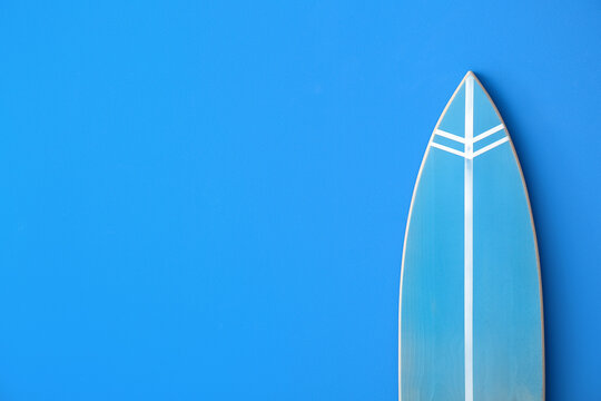 Blue surfboard on color background