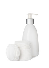Cotton pads and bottle of cosmetic product on white background