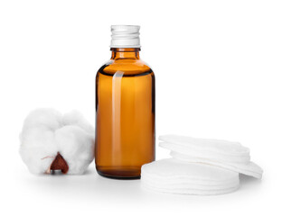Cotton pads, flower and bottle of cosmetic product on white background