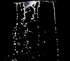 Naklejka na ściany i meble splashing milk on black background