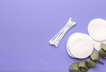 Fototapeta premium Cotton pads, swabs and eucalyptus branch on color background