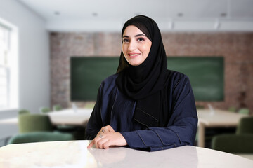 Arabic teacher portrait inside the classroom. Emirati woman on Abaya Hijab