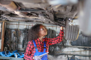 Fototapeta na wymiar Female auto mechanic working at the repair shop.