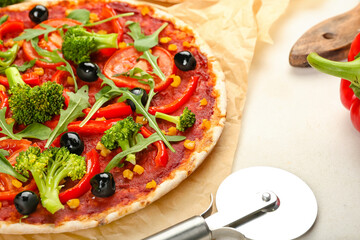 Parchment with tasty vegetarian pizza on light background, closeup