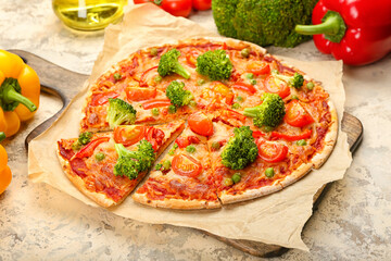Board with tasty vegetarian pizza on light background