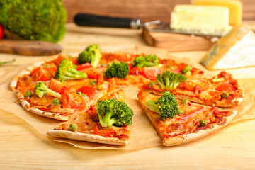 Parchment with tasty vegetarian pizza on wooden background