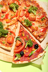 Board with tasty vegetarian pizza on color background