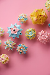 Set of multicolor handmade modular origami balls or Kusudama Isolated on pink background. Visual...