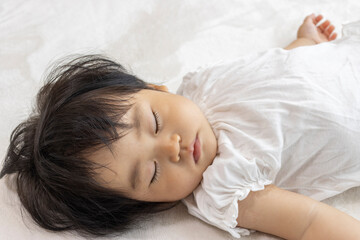 Obraz na płótnie Canvas 窓際で寝る赤ちゃん（1歳、日本人、女の子）