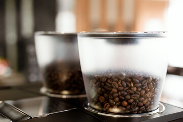 Close up coffee beans in a machine jar