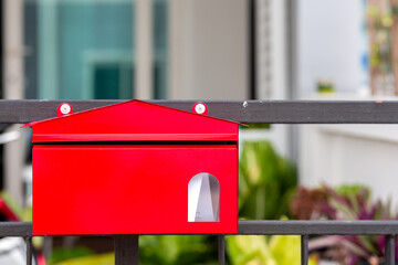 Red mailbox or postal box on fence in Front of a House