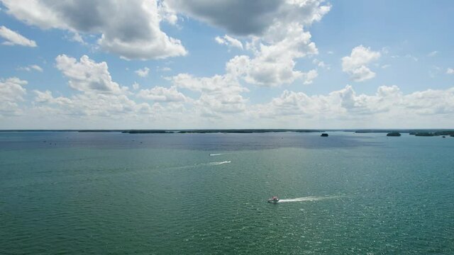 Aerial view of Lake with shiny water and green trees. Sun reflection in the water. Beautiful spring landscape with open water